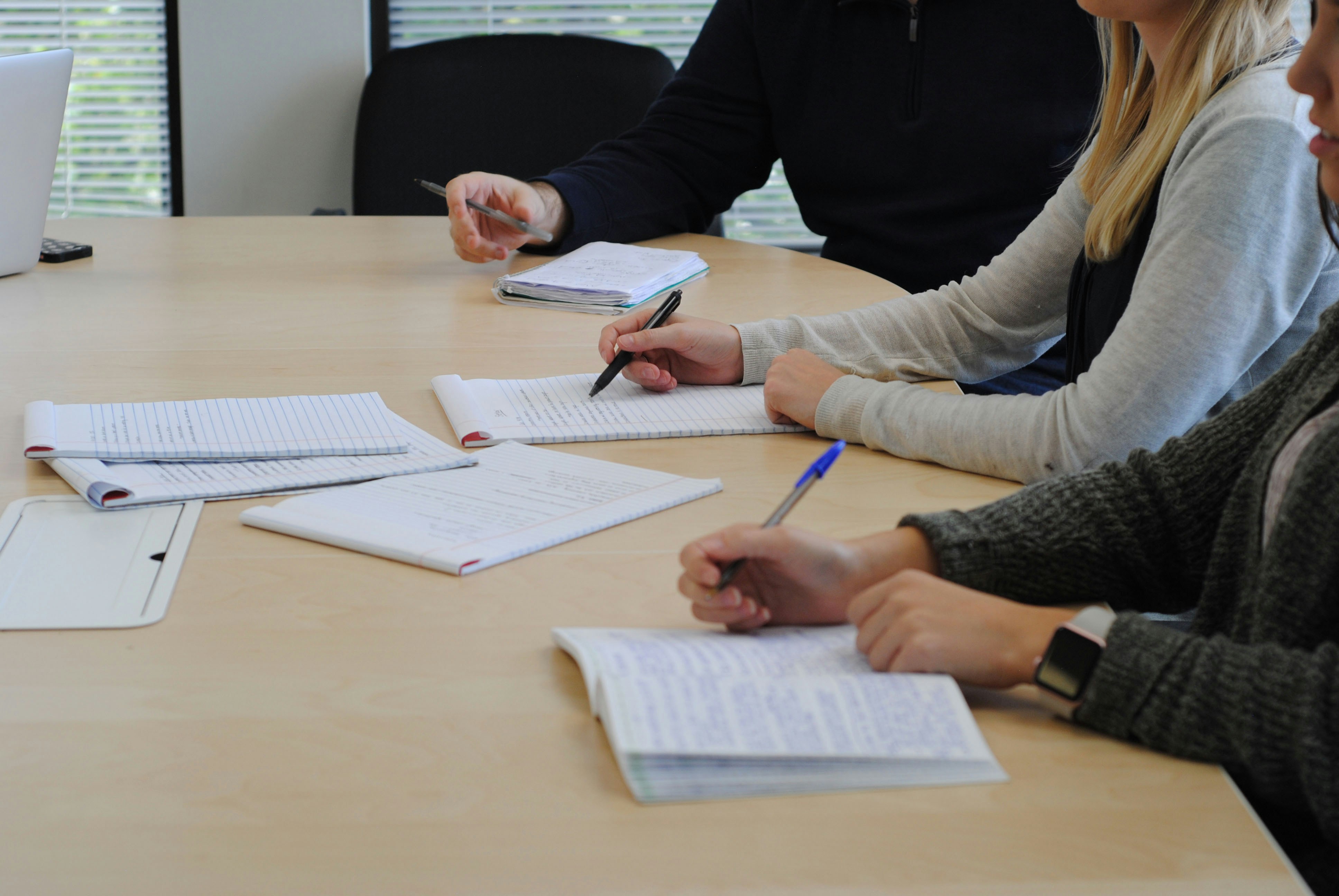 Adviseurs en een klant werken samen aan documenten aan tafel